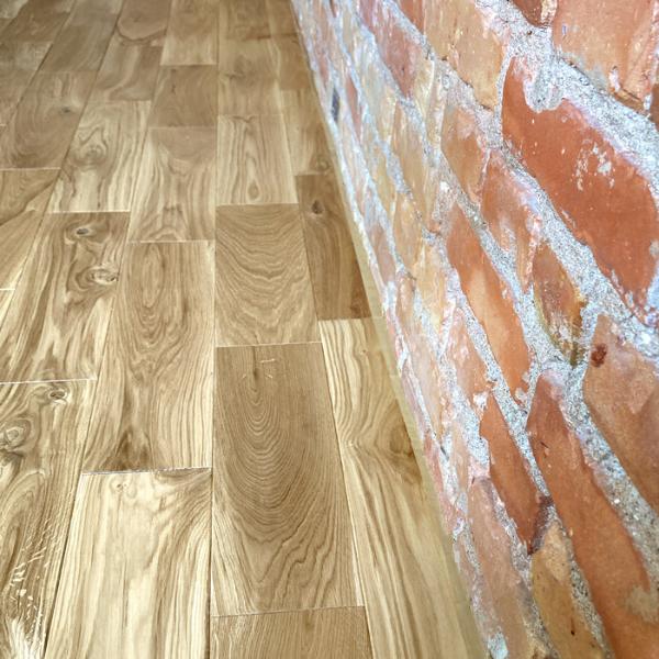 skaista ķieģeļu siena satiekas ar ozolkoka grīdu. kvalitatīvs darbs un rūpīga attieksme pret klientiem un materiālu. Profesionāli izpildīts darbs ir būtisks, lai iegūtu izcilu rezultātu un nodrošinātu, ka ozolkoka grīda kalpos ilgu laiku, nepazaudējot savu skaistumu. Šāda veida rūpīgs pieeja ir ieguldījums jūsu telpas estētikā un kvalitātē, un tas var radīt mājīgu un siltu atmosfēru jūsu telpās.