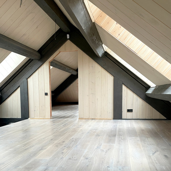 skaista baltināta ozoloka grīda ar izteiksmīgiem antracīta krāsas baļku elementiem, gaiša grīda un gaišas koka sienas