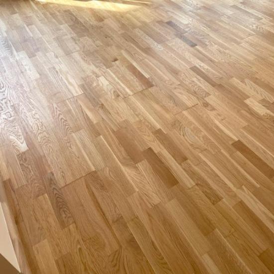 Kvalitatīvi un rūpīgi veikta trīsslāņu ozola parketa atjaunošana nodrošināja pilnīgu pāslīpēšanu līdz tīram ozolkoka slānim. Lai izceltu unikālo tekstūru un piesātināto toni, parkets tika piesūcināts ar Osmo Klarwachs un divreiz pārklāts ar Osmo eļļas ciet, nodrošinot izturību un dabisku eleganci. Meistaru rūpīgais un kvalitatīvais darbs garantē ilgmūžību, saglabājot grīdas skaistumu un noturību.