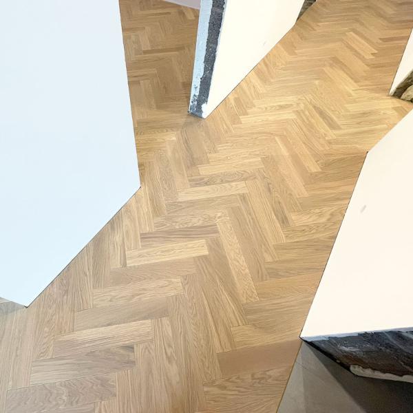 Skujiņas raksts no ozolkoka parketa dod grīdai un telpai kopumā elegances un tradicionālu izskatu. Ozolkoka raksts var būt bagāts un mainīgs, kas rada vizuālu interesi. Divslāņu konstrukcija: Divslāņu parkets ir stabilāks un izturīgāks pret temperatūras un mitruma izmaiņām, kas ir svarīgi, ja tas tiek ieklāts uz betona apsildāmas grīdas.