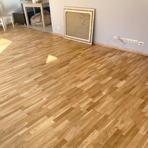 Kvalitatīva darba rezultāts ir būtisks. Trīsslāņu ozola parketa grīda tika pāslīpēta līdz tīram ozolkoka slānim, ļaujot izcelt tā unikālo tekstūru un piesātināto toni. Lai nodrošinātu izturību un ilglaicīgu skaistumu, parkets tika piesūcināts ar Osmo Klarwachs un divreiz pārklāts ar Osmo eļļas ciet. Meistaru rūpīgi un kvalitatīvi veiktais darbs garantē ne tikai dabisku eleganci, bet arī grīdas noturību un ilgmūžību.