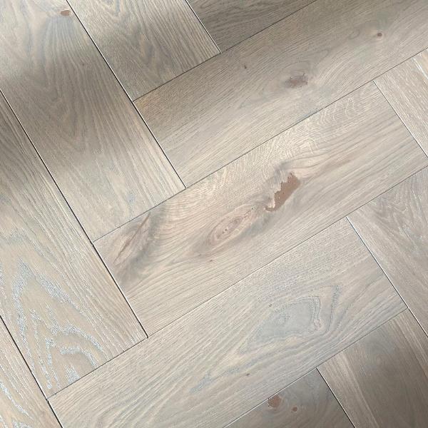Ozolkoka parketa grīda ieklāta uz sagatavotas pamatnes, un tonēta uz vietas objektā. Pelēkās krāsas kontrasts gaišā interjerā piešķir telpai interesantu vizuālo dinamiku. Dēļu ieklāšana ir precīzs darbs, kuru vislabāk uzticēt pieredzējušiem grīdas speciālistiem, lai nodrošinātu kvalitatīvu un izturīgu rezultātu.