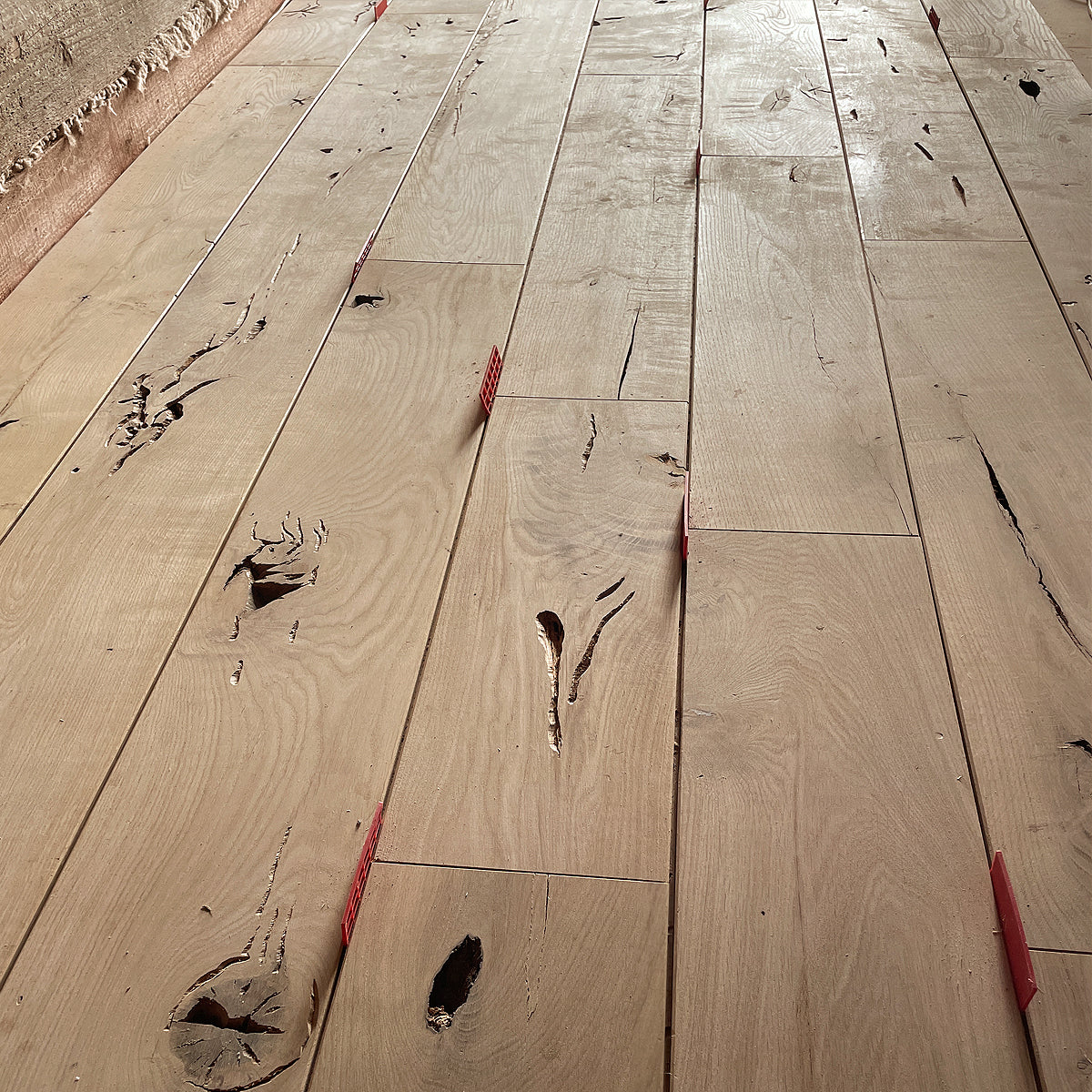 DIY padoms: ja vēlaties mierīgāku, askētiskāku koka rakstu, izvēlieties „Natur” šķirojumu, kur dēļiem ir vienmērīgāka tekstūra un maigāks tonis.
DIY padoms: katru Osmo eļļas cietā vaska slāni uzklāj plānā kārtā, neveidojot biezu pārklājumu. Šajā gadījumā, labāk ir mazāk, lai neveidotos notecējumi un negludumi.

Profesionāļu ieteikums: šajā etapā var izmantot arī tonētas Osmo beices, ja vēlaties gaišākus sienas paneļus. Piemēram, balto 3501 Osmo beici, kas ļauj iegūt balinātu dekoratīvu ozolkoka virsmu. 